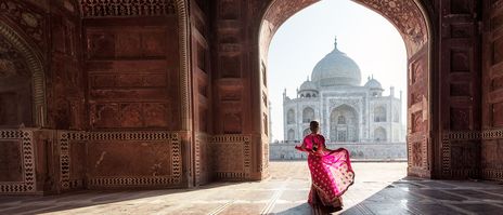 Frau im pinken Sari posiert vor dem Taj Mahal in Agra