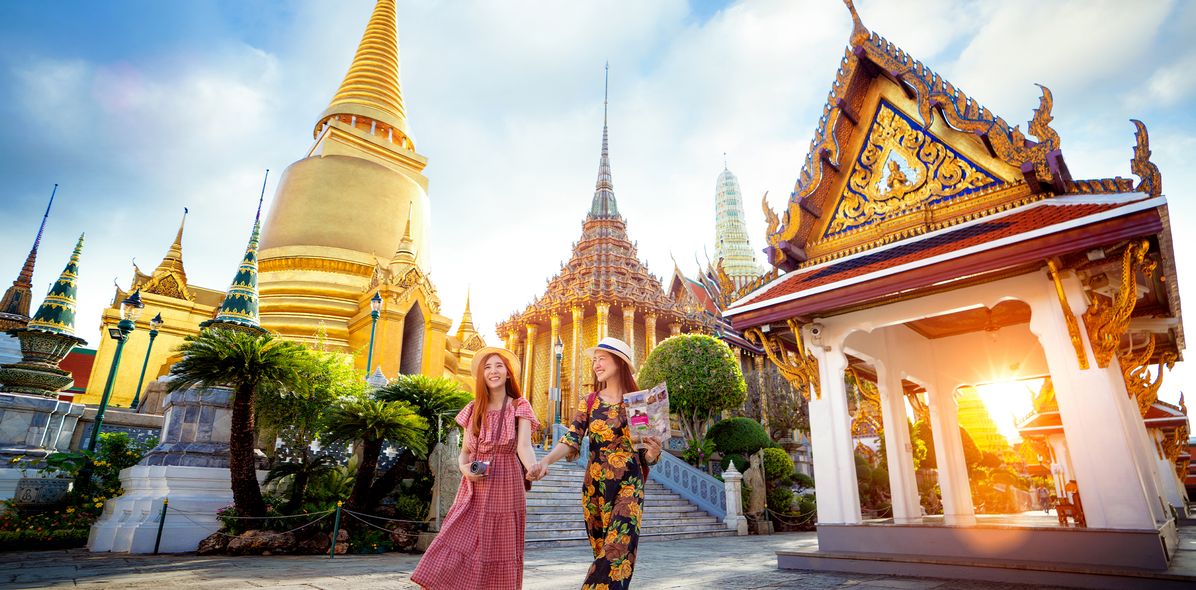 Zwei Frauen vor mehreren Tempeln in Bangkok