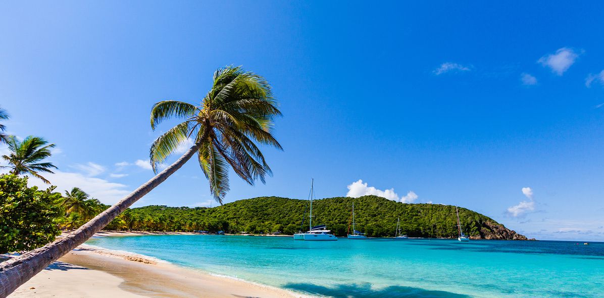 Blick auf einen Karibikstrand mit Booten in der Bucht
