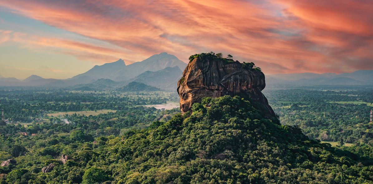 Der mächtige Löwenfelsen Sigiriya im goldenen Licht des Sonnenuntergangs, umgeben von tropischem Dschungel