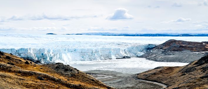 Gletscherzunge in weiter arktischer Landschaft in Kangerlussuaq mit Eis und Felsen