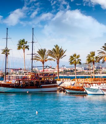 Hafen von Side mit Booten, Palmen, Promenade und strahlend blauem Himmel