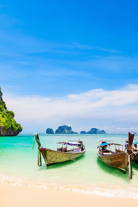 Traditionelle Boote am ruhigen Strand von Ko Samui mit klarem Meer und Himmel