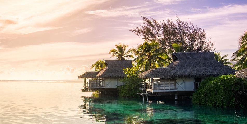 Schwimmende Bungalows auf den Malediven bei Sonnenuntergang