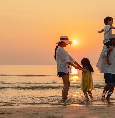 Familie am Strand bei Sonnenuntergang