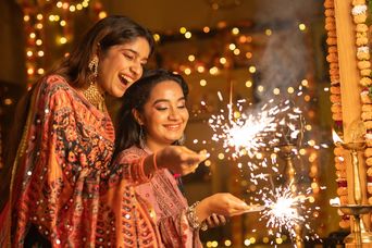 Frauen mit Wunderkerzen in der Hand beim Diwali Fest