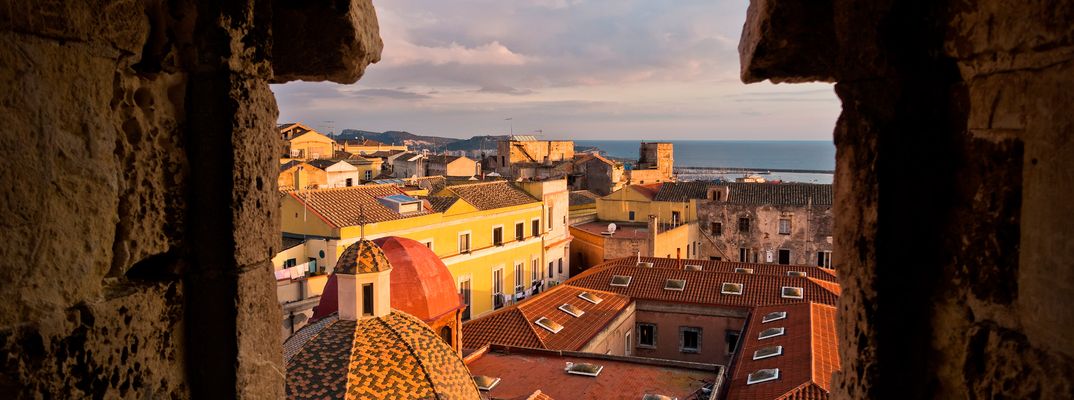 Blick über Cagliari durch eine Gasse mit Altstadtpanorama