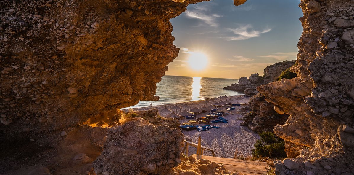 Blick aus Höhle auf Strand bei Sonnenuntergang