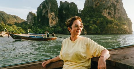 Frau genießt eine Bootsfahrt vor den Kalksteinfelsen der thailändischen Inselwelt bei Krabi