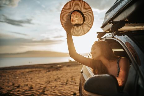 Frau im Auto am Strand