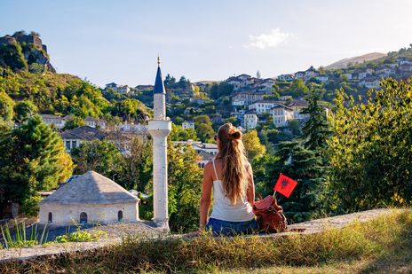 Gjirokastra Frau sitzt auf einem Hügel mit Stadtblick