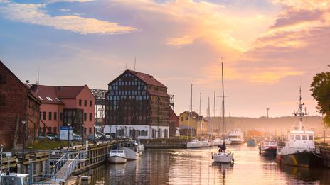 Hafen von Klaipėda bei Sonnenuntergang mit historischen Speichern und Booten