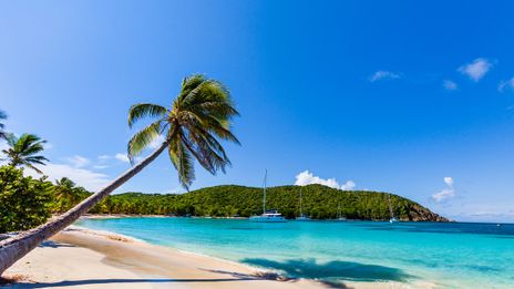 Blick auf einen Karibikstrand mit Booten in der Bucht
