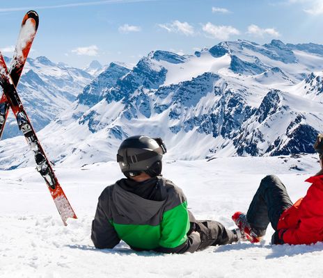 Männer während einer Skipause liegend im Schnee