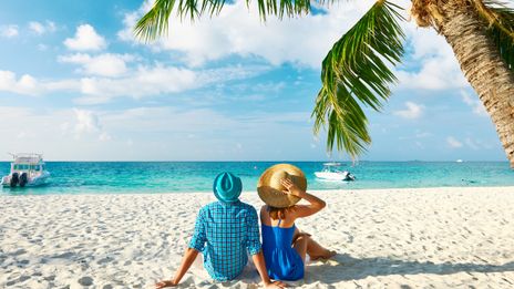 Paar sitzt am Strand auf den Malediven