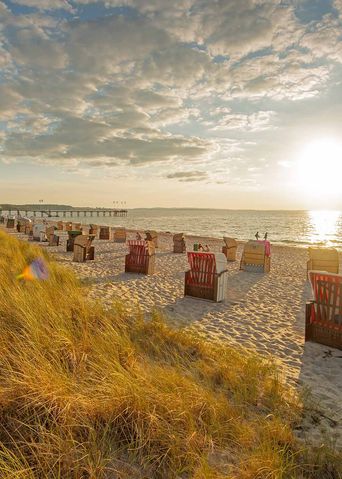 Der Weissenhäuser Strand in Mecklenburg Vorpommern mit Strandkörben während des Sonnenuntergangs
