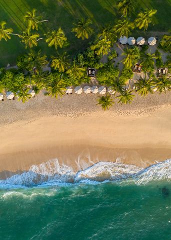 Luftaufnahme eines einsamen Sandstrands mit türkisblauem Meer an der Südküste Sri Lankas