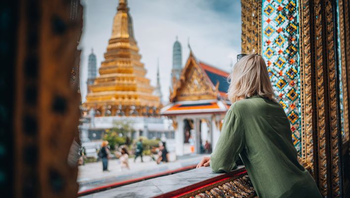 Frau blickt auf Tempel in Bangkok