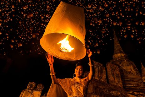 Eine Frau mit einer Himmelslaterne auf dem Loy Krathong Laternenfest in Thailand