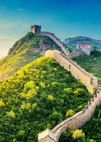 Die Chinesische Mauer schlängelt sich durch grüne Berge