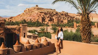 Eine Frau blickt auf die historischen Lehmbauten von Ait-Ben-Haddou 