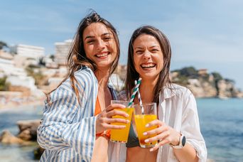 Frauen am Strand mit Cocktails
