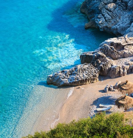  Der malerische Strand von Himare an der albanischen Riviera mit türkisfarbenem Wasser und Sonnenschirmen