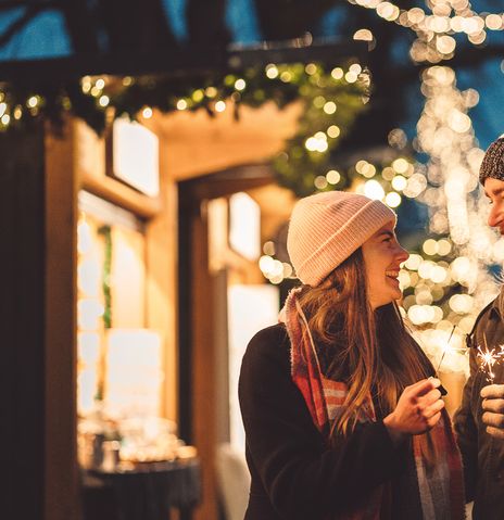 Paar mit Wunderkerzen am Weihnachtsmarkt