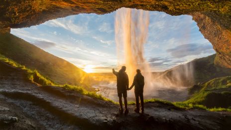Paar vor dem Seljalandsfoss bei Sonnenaufgang
