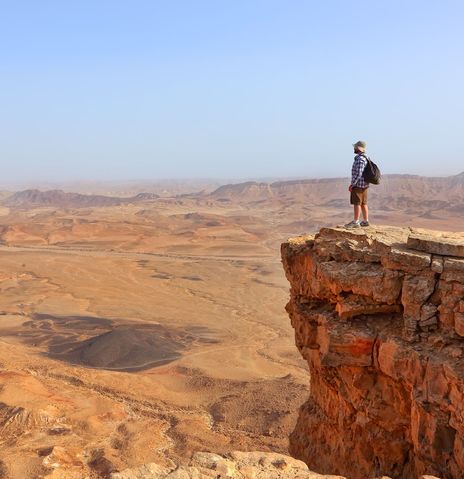 Mann auf Felsen in der Negev Wüste