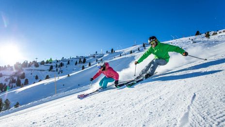 Paar auf der Piste beim Skifahren