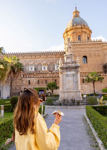 Frau vor der Kathedrale von Palermo mit Palmen und Platz