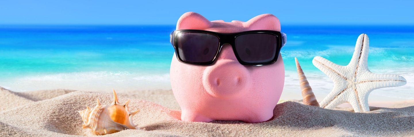 Sparschwein mit Sonnenbrille am Strand