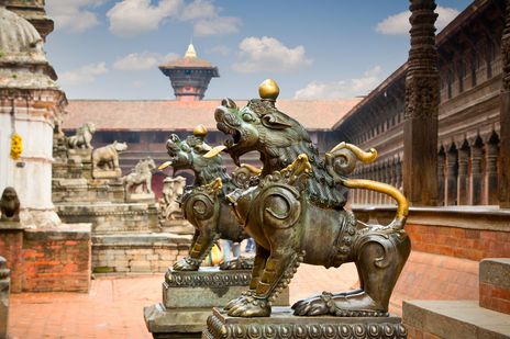 Historischer Tempelplatz in Bhaktapur mit Löwenstatue und traditioneller Architektur
