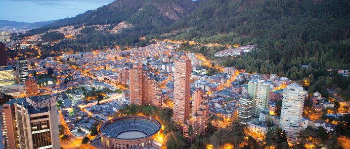 Blick über Bogotá bei Abendlicht mit Bergen und dichter Stadtbebauung