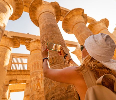 Frau beim Fotografieren der Säulen in der Tempelanlage von Karnak in Luxor, Ägypten