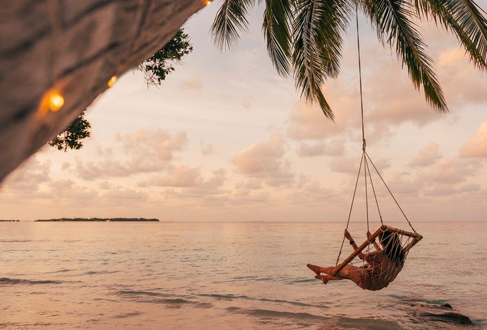 Frau auf einer Schaukel am Meer