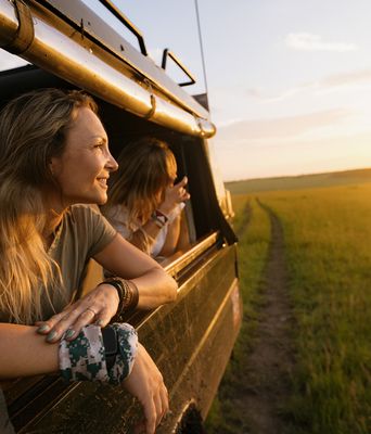 Frauen blicken aus einem Geländewagen bei einer Safari in Kenia