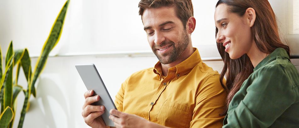 Mann und Frau schauen interessiert auf ein Tablet