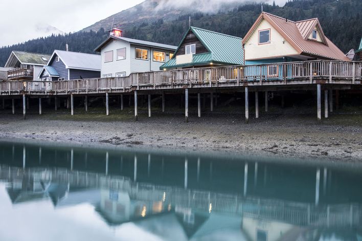 Blick auf den Küstenort Seward mit Häusern auf Stelzen am Hafen