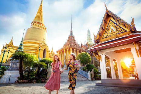 Frauen spazieren entlang einer Tempelanlage in Bangkok
