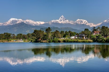 Pokhara am Phewa-See mit Bergen, Stadt und ruhiger Wasseroberfläche