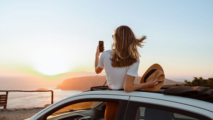 Frau mit Handy im Auto