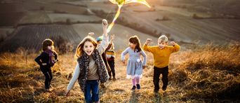 Kinder mit Drachen auf dem Feld
