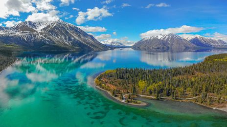 Flusslandschaft im Yukon mit smaragdgrünem Wasser und bewaldeten Hügeln