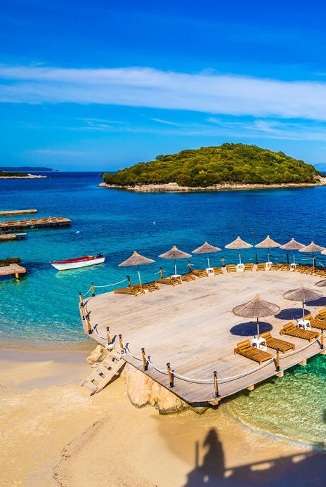Strand mit Liegestühlen und Insel