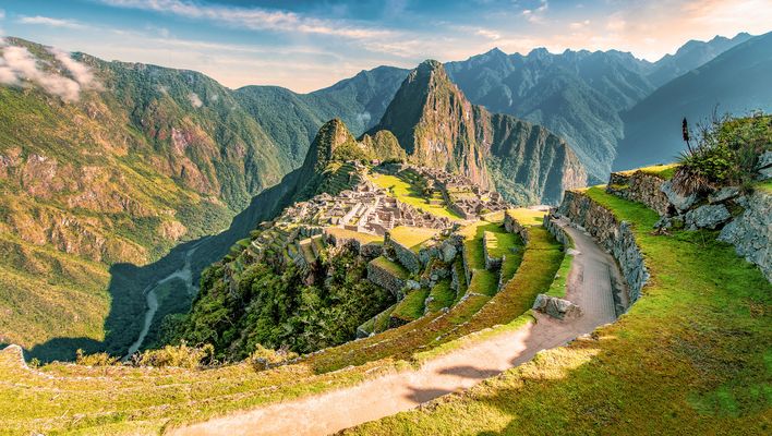 Panoramablick auf Machu Picchu mit Serpentinenweg und grünen Berghängen