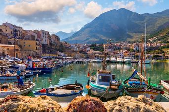 Blick auf den Hafen von Trapani auf Sizilien in Italien auf Fischerboote und bunte Häuser