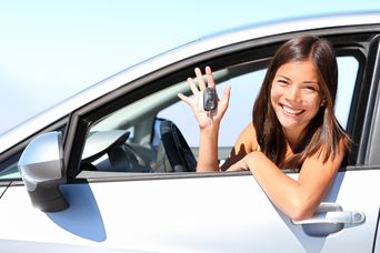 Frau sitzt in einem Mietwagen