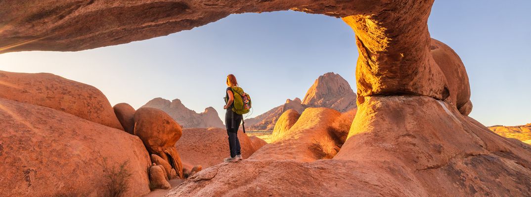 Frau steht auf einem Felsen am Spitzkoppe in Namibia
